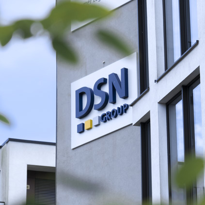 Außenansicht eines Bürogebäudes mit dem Logo der DSN Group an der Fassade.