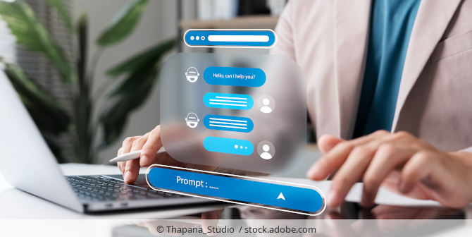 Person sitzt an Schreibtisch und nutzt Chatbot.